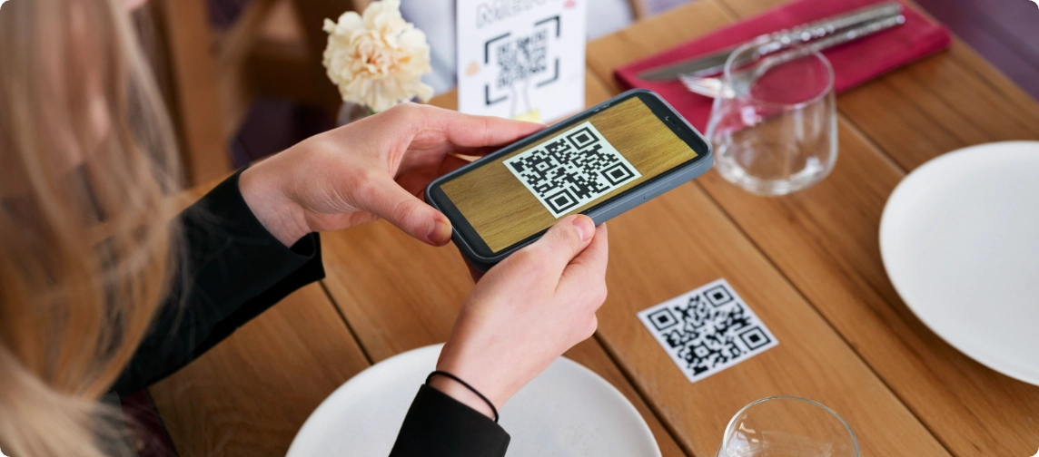 mujer escaneando qr en una mesa con platos