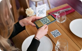 mujer escaneando qr en una mesa con platos