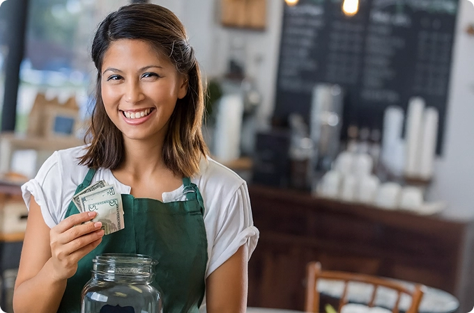 barista mujer sosteniendo billetes en la mano