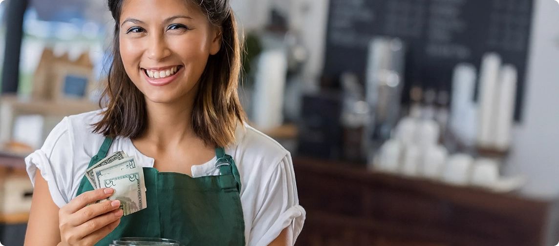 barista mujer sosteniendo billetes en la mano