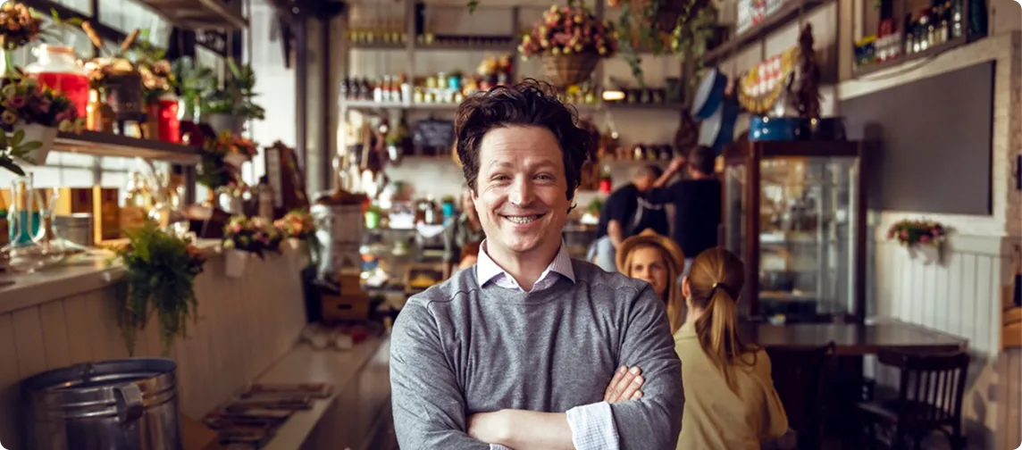 dueño de restaurante sonriendo frente a la cámara